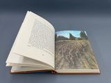 an open book with a picture of a field on it