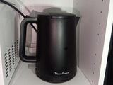 a black kettle sitting on a shelf in a microwave