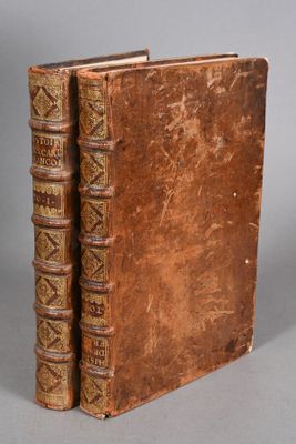 an old book sitting on top of a table next to another book