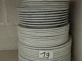 several stacks of white plates stacked on top of each other on a shelf