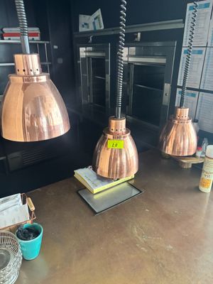 trois lampes en cuivre suspendues au plafond d'une cuisine