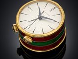 a gold watch with a red, green, and yellow band