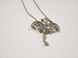 a close up of a necklace on a white surface