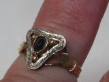 une personne tenant une bague sertie d'une pierre noire