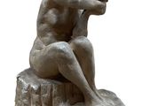statue of a man sitting on a rock with his head in his hands