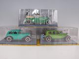three toy cars in a display case on a table
