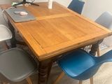 a wooden table with blue chairs and a computer on it