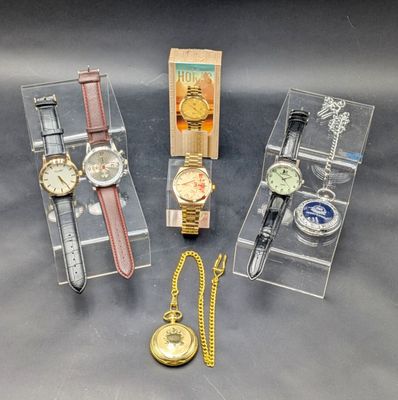 trois montres et une montre dans une vitrine posée sur une table