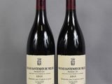two bottles of wine sit on a table with a gray background
