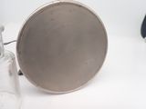 a silver pan sitting next to a glass bottle on a table