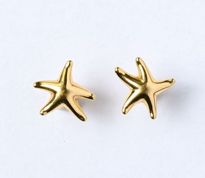 une paire de boucles d'oreilles en forme d'étoiles de mer dorées sur fond blanc