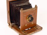 an old camera that is sitting on a wooden stand