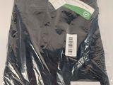 a black shirt wrapped in plastic on a white surface