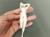 someone is holding a small figurine of a woman in a dress