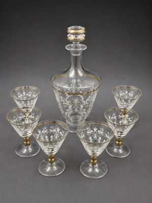 six glass wine glasses and a decanter on a table