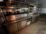 une cuisine équipée de plans de travail et d'appareils électroménagers en acier inoxydable