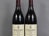 two bottles of wine sitting on top of a table next to each other