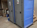 deux toilettes portables dans un garage équipé d'un escalier