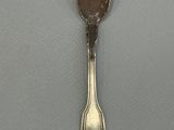 silver spoon with chocolate on it sitting on top of a gray surface