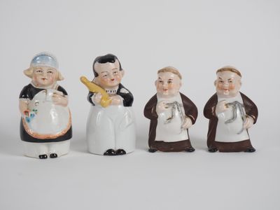 four ceramic figurines of people dressed in different outfits
