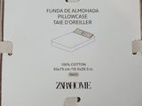 brown and white striped pillow with a tag on it