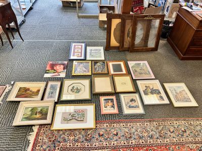 a lot of framed pictures on the floor in the room