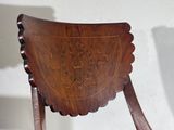a wooden chair with a carved design on the back