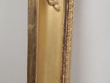 a mirror with a gold frame hanging on the wall