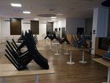 des rangées de chaises dans une pièce au sol en parquet et aux murs blancs