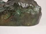 a bronze sculpture of a bird perched on top of a rock