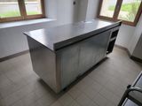 a large stainless steel island in the middle of a kitchen