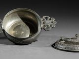 une tasse en argent avec un couvercle, posée à côté d'une autre tasse