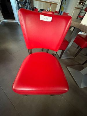 une chaise rouge qui se trouve au milieu d'une pièce