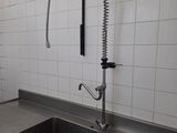 a kitchen sink with a faucet and a window in the background