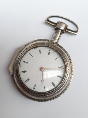 une montre de poche en argent avec des chiffres romains