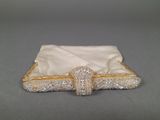 an image of a white and gold purse with a bow on it