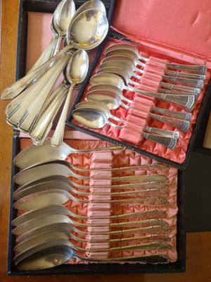 de nombreuses cuillères et cuillères-cuillères dans une boîte posée sur une table