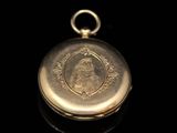 an antique gold pocket watch with a picture of a woman on it