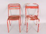 two red chairs sitting next to each other on a white surface