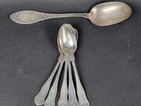 five spoons and two spoons on a black surface