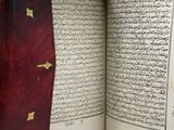 an open book with arabic writing on it sitting on top of a table
