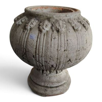 un vase en pierre posé sur une surface blanche