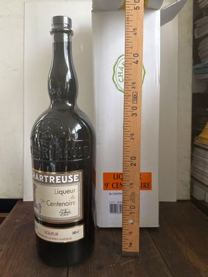 une bouteille de vin posée sur une table à côté d'une règle