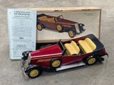 une petite voiture rouge avec une boîte par terre