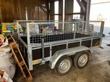 a trailer with a cage on the back of it in a barn