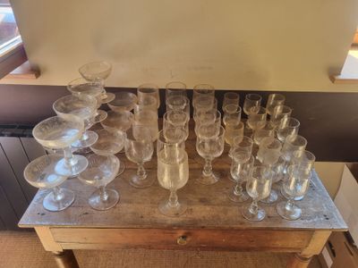 many empty wine glasses sitting on a wooden table