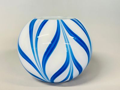 a blue and white striped vase on a white table