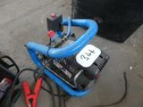 un compresseur d'air bleu posé par terre à côté d'autres outils