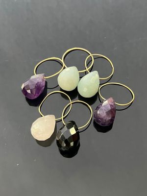 a bunch of rings with different colored stones on a black surface