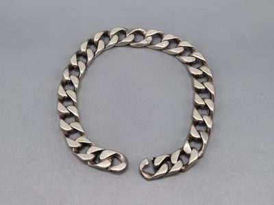 un bracelet en argent avec une grosse chaîne à maillons sur fond gris